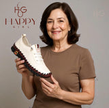 Mujer sonriente sosteniendo zapatilla mujer blanca Happy Girl de ALL ONLINE 24 con suela flexible y diseño cómodo